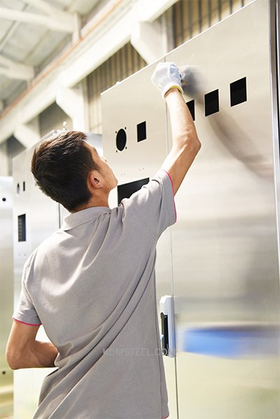 worker clearning the NEMA 4 stainless steel enclosure
